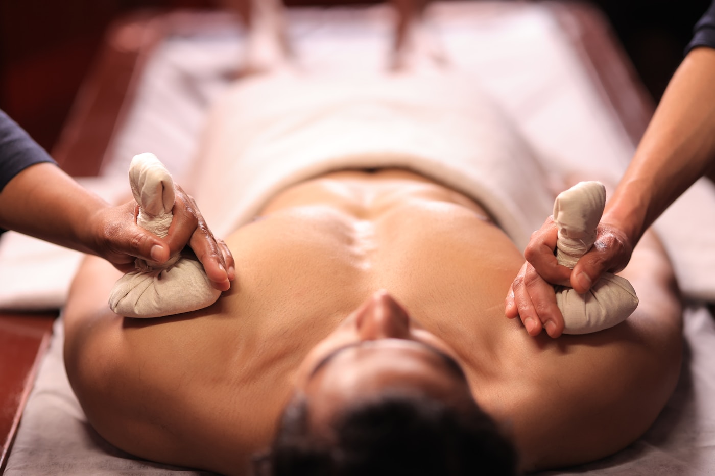Kräuterstempel-Massage mit warmen Kräuterstempeln